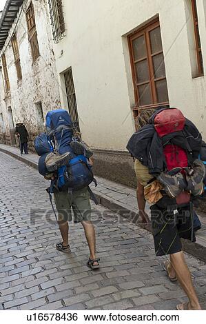 Two tourists carrying backpacks in a alley in Barrio De San Blas, Cuzco, Peru View Large Photo Image Stock Photograph - Two tourists carrying backpacks in a alley in Barrio De San Blas, Cuzco, Peru. Fotosearch