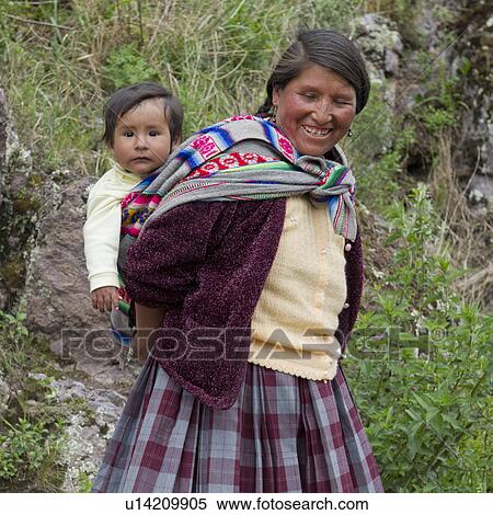 Woman carrying her son on back and smiling, Pisac, Sacred Valley, Cusco Region, Peru View Large Photo Image Stock Photography - Woman carrying her son on back and smiling, Pisac, Sacred Valley, Cusco Region, Peru. Fotosearch
