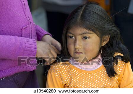 Stock Image - Woman combing her daughter's hair, Barrio de San Blas, Cuzco, Peru. Fotosearch