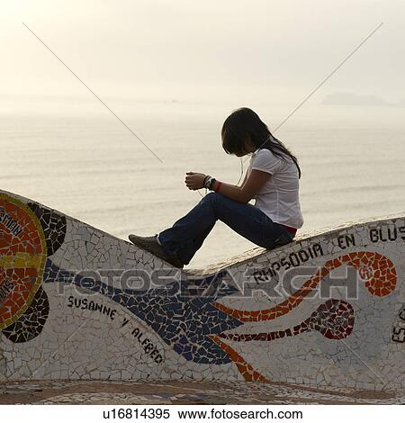 Stock Photography - Woman listening to MP3 player in a park, El Parque Del Amor, Av De La Aviacion, Miraflores District, Lima Province, Peru. Fotosearch