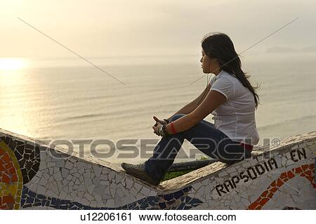 Stock Image - Woman looking at sunset from El Parque del Amor, Av De La Aviacion, Miraflores District, Lima Province, Peru. Fotosearch