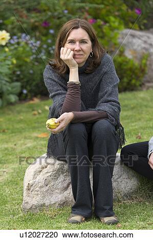Stock Image - Woman sitting in the lawn of Willka Tika Guesthouse, Willka Tika, Sacred Valley, Cusco Region, Peru. Fotosearch