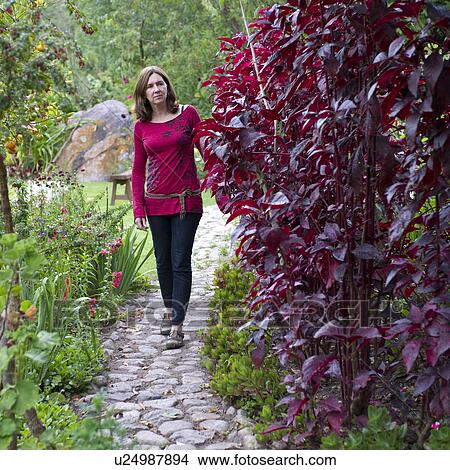 Picture - Woman walking in the garden of Willka Tika Guesthouse, Willka Tika, Sacred Valley, Cusco Region, Peru. Fotosearch