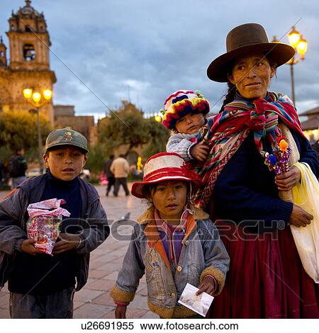 Stock Photography - Woman with her children at a town square with Iglesia de la Compania in the background, Plaza de Armas, Cuzco, Peru. Fotosearch