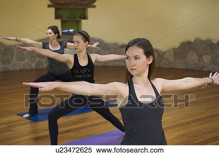 Stock Photography - Women practicing warrior 2 pose in a gym, Willka Tika Guesthouse, Willka Tika, Sacred Valley, Cusco Region, Peru. Fotosearch