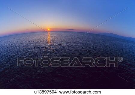 Picture - Aerial view of horizon over sea at sunrise. Fotosearch