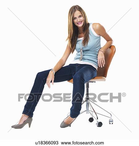 Attractive woman sitting on chair and smiling against white background View Large Photo Image Stock Image - Attractive woman sitting on chair and smiling against white background. Fotosearch