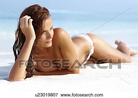 Attractive young woman relaxing on beach View Large Photo Image Stock Photo - Attractive young woman relaxing on beach. Fotosearch
