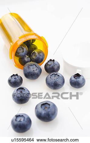 Picture - Blueberries spilling from prescription bottle. Fotosearch