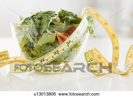 Stock Photograph - Bowl of salad and tape measure. Fotosearch