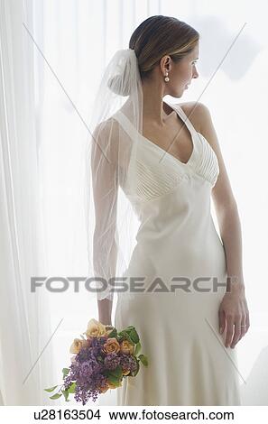Picture - Bride holding floral bouquet. Fotosearch