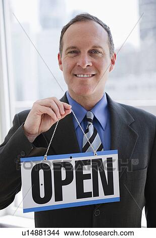 Picture - Businessman holding open sign. Fotosearch