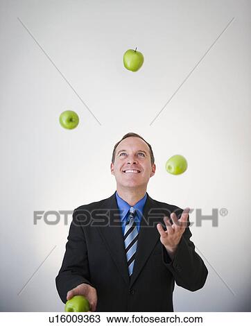 Stock Image - Businessman juggling apples. Fotosearch