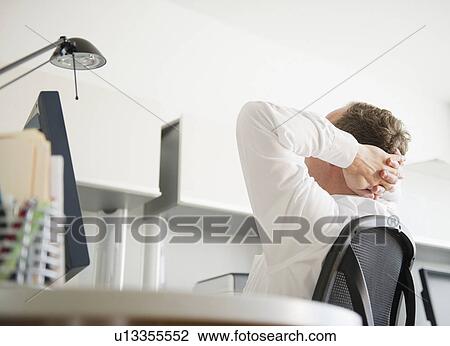 Stock Image - Businessman relaxing in office. Fotosearch