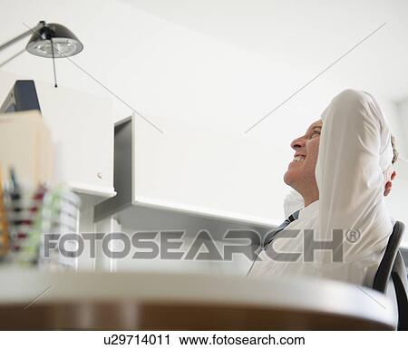 Stock Image - Businessman relaxing in office. Fotosearch