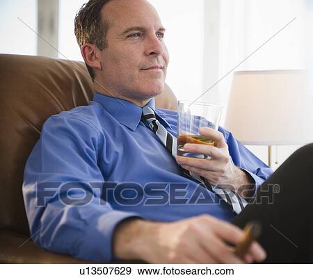 Stock Photo - Businessman relaxing with drink and cigar. Fotosearch