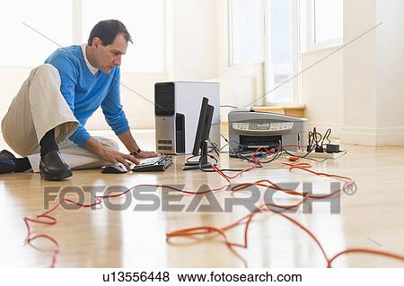 Stock Photo - Businessman setting up internet in new office. Fotosearch