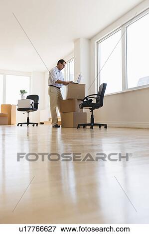Businessman setting up office View Large Photo Image Stock Photo - Businessman setting up office. Fotosearch