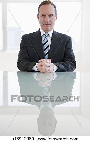 Stock Photo - Businessman sitting at table. Fotosearch