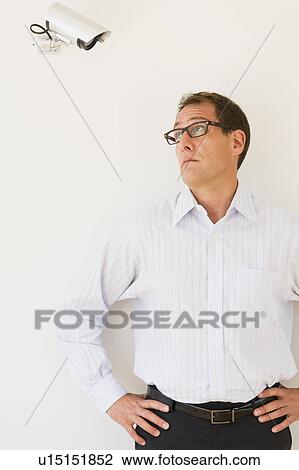 Businessman under surveillance of security camera View Large Photo Image Stock Image - Businessman under surveillance of security camera. Fotosearch