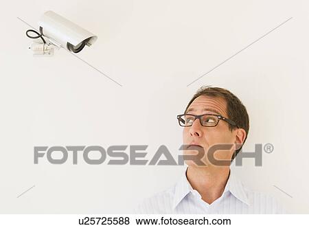 Businessman under surveillance of security camera View Large Photo Image Stock Photo - Businessman under surveillance of security camera. Fotosearch