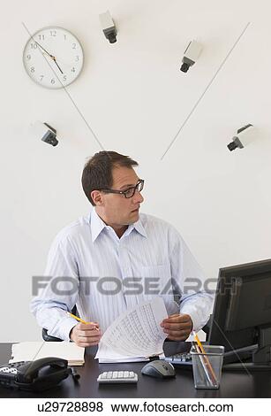 Stock Photo - Businessman under surveillance of security cameras. Fotosearch
