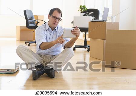 Picture - Businessman using palmtop in new office. Fotosearch