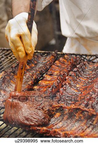 Stock Photography - Chef cooking spareribs on barbeque. Fotosearch