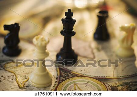 Stock Image - Chess pieces on old world map. Fotosearch