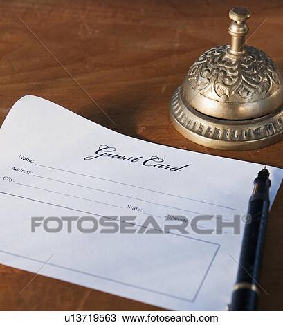 Stock Image - Close up of antique guest card and service bell. Fotosearch