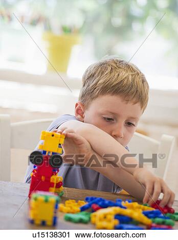 Stock Image - Close up of boy (4-5) playing with plastic blocks. Fotosearch