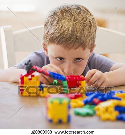 Close up of boy (4-5) playing with plastic blocks View Large Photo Image Stock Photo - Close up of boy (4-5) playing with plastic blocks. Fotosearch