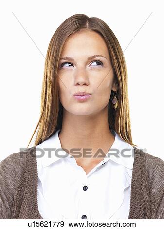 Stock Photo - Close-up of business woman pursing her lips and looking up. Fotosearch