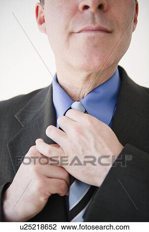 Close up of businessman tying tie View Large Photo Image Stock Image - Close up of businessman tying tie. Fotosearch