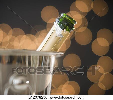 Stock Image - Close up of champagne in ice bucket. Fotosearch
