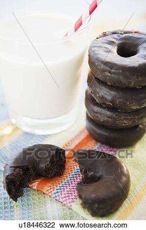 Close up of chocolate donuts and milk View Large Photo Image Stock Image - Close up of chocolate donuts and milk. Fotosearch