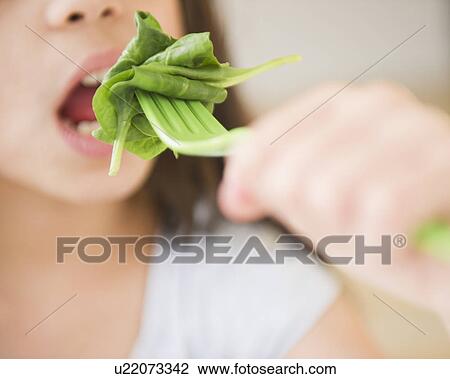 Close up of girl (10-11) eating salad View Large Photo Image Stock Image - Close up of girl (10-11) eating salad. Fotosearch