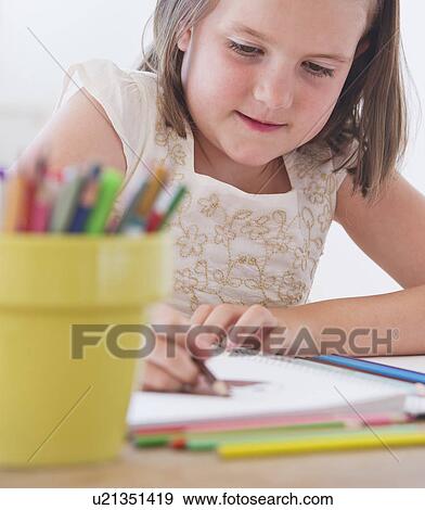 Stock Photo - Close up of girl (6-7) drawing in notebook. Fotosearch