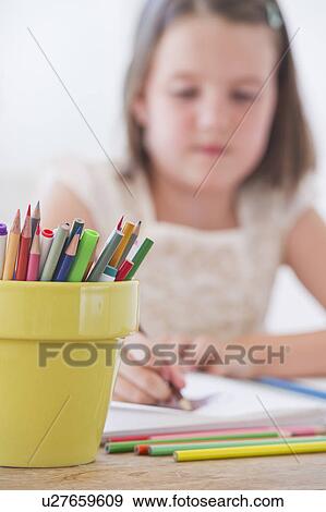 Stock Photo - Close up of girl (6-7) drawing in notebook. Fotosearch