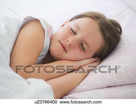 Stock Image - Close up of girl (6-7) sleeping in bed. Fotosearch