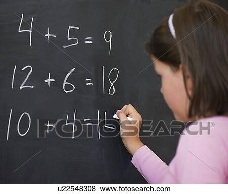 Stock Photo - Close up of girl (6-7) writing on blackboard. Fotosearch