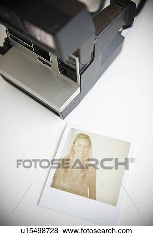 Stock Photo - Close up of photograph of woman and polaroid camera. Fotosearch