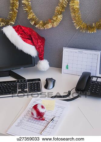 Close Up Of Santa Hat And Christmas Decorations On Office Desk