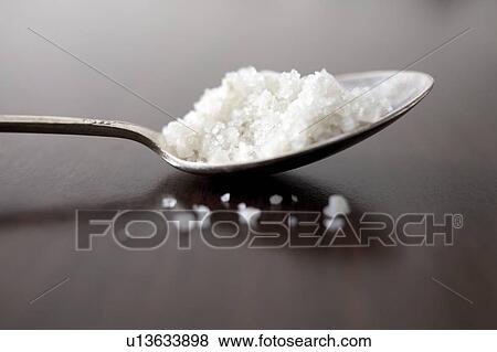 Stock Photo - Close-up of sea salt on spoon. Fotosearch