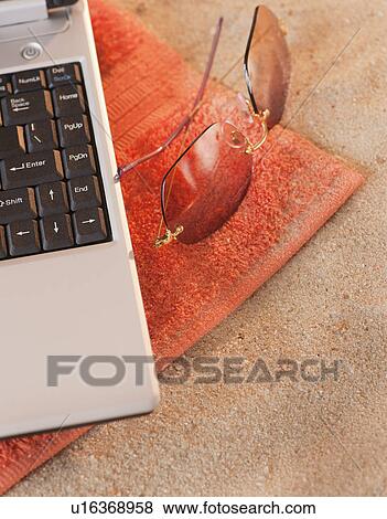 Close up of sunglasses and laptop on towel View Large Photo Image Stock Photo - Close up of sunglasses and laptop on towel. Fotosearch