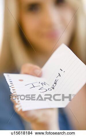 Picture - Close up of woman showing apologize message. Fotosearch