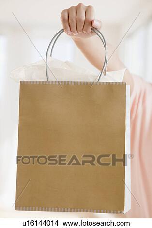 Picture - Close up of woman's hand holding shopping bag. Fotosearch