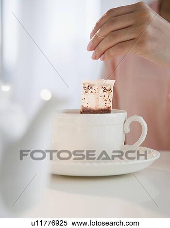 Close up of woman's hand putting teabag into tea cup View Large Photo Image Stock Photography - Close up of woman's hand putting teabag into tea cup. Fotosearch