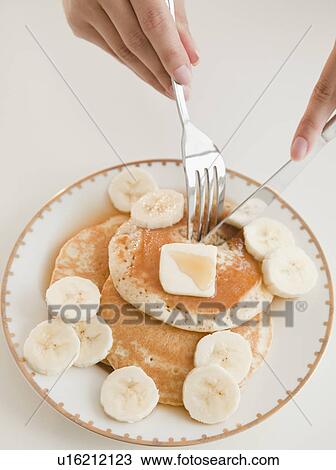 Close up of woman's hands and pancakes with banana View Large Photo Image Stock Image - Close up of woman's hands and pancakes with banana. Fotosearch