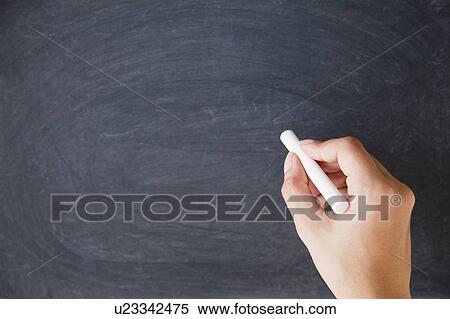 Stock Photography - Close up of woman's hands writing with chalk on blackboard. Fotosearch